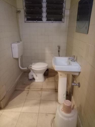 a bathroom with a toilet and a sink at hotel sangeeth lodging in Mysore