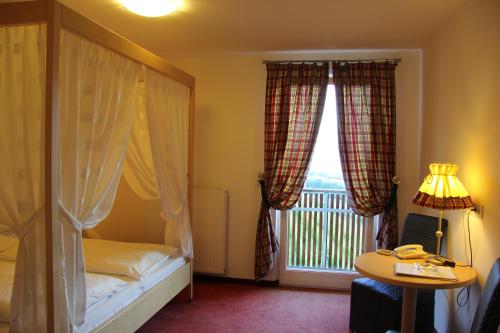 a bedroom with a bed and a window with a balcony at Hotel Hanny in Bolzano