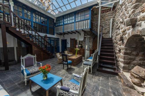 an indoor patio with chairs and a table and stairs at X.O Art House in Cusco