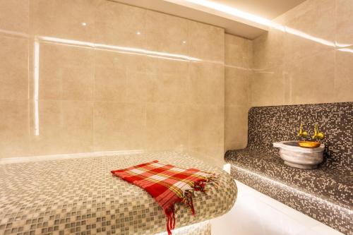 a bedroom with a bed with a plaid towel on it at Hotel Orlovetz in Pamporovo