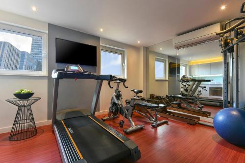 a gym with three exercise bikes and a flat screen tv at Fraser Place Canary Wharf in London