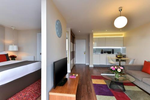 a bedroom and a living room with a bed and a kitchen at Fraser Place Canary Wharf in London