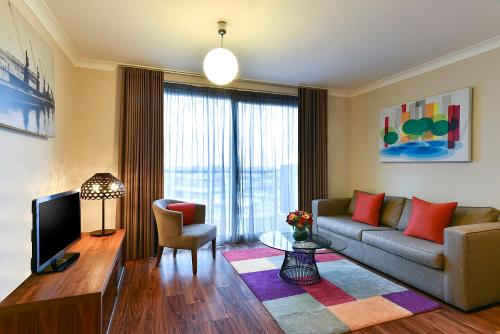 a living room with a couch and a tv at Fraser Place Canary Wharf in London