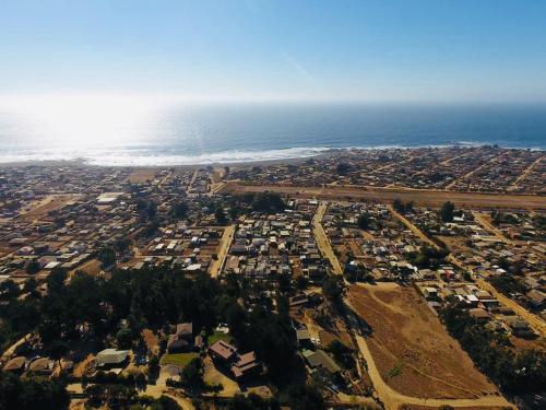 an aerial view of a city and the ocean at Cabaña del Bosque in Pichilemu