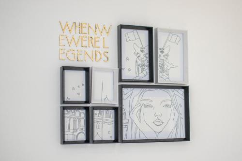 a group of four framed drawings on a wall at X.O Art House in Cusco