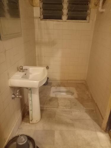 a bathroom with a sink and a toilet at hotel sangeeth lodging in Mysore