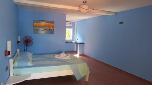 a blue bedroom with a bed with a blue wall at Binucot Beach Resort in Ferrol