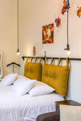 a bedroom with two beds with yellow cushions at X.O Art House in Cusco