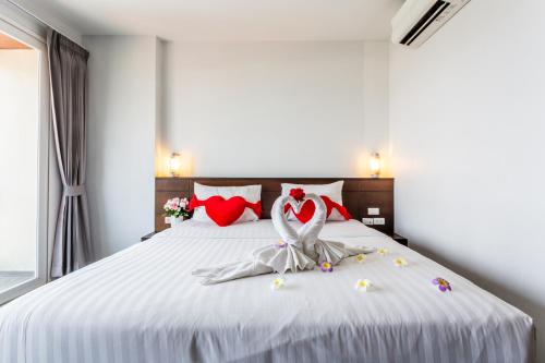 a bedroom with a white bed with red pillows at 77 Bangla Hotel - Patong Phuket in Patong Beach