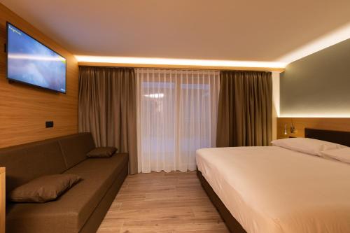 a hotel room with a bed and a couch at Hotel Centro's in Livigno