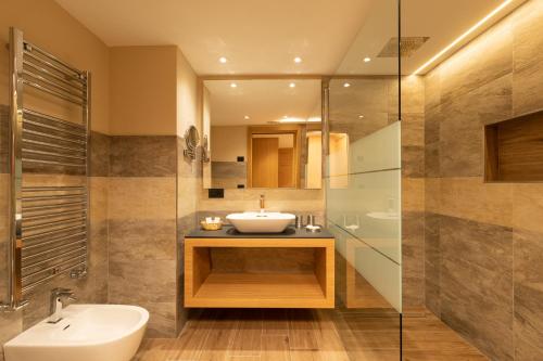 a bathroom with a sink and a shower at Hotel Centro's in Livigno