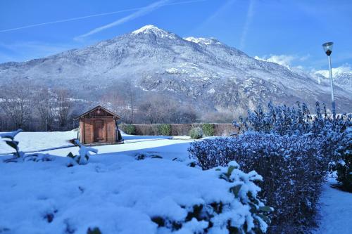 a small wooden cabin with a mountain in the background at B&B HOTEL Saint Jean De Maurienne in Sainte-Marie-de-Cuines
