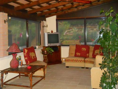 a living room with two couches and a tv at B&B Silent Valley in Ripatransone