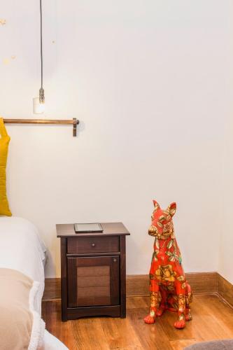 a toy dog sitting on the floor next to a table at X.O Art House in Cusco