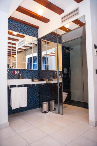a bathroom with a large mirror and blue tiles at Posada del León de Oro Boutique Hotel in Madrid