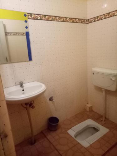 a bathroom with a sink and a toilet at hotel sangeeth lodging in Mysore