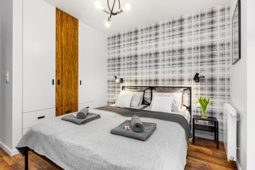 a bedroom with a bed with two towels on it at Apartamenty Black&White - Apartament Loft Style in Gdynia
