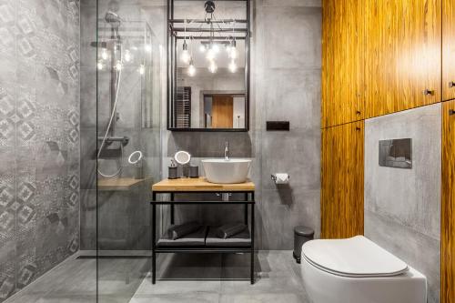 La salle de bains est pourvue d'un lavabo et de toilettes. dans l'établissement Apartamenty Black&White - Apartament Loft Style, à Gdynia