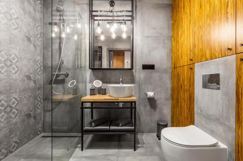 a bathroom with a sink and a toilet at Apartamenty Black&White - Apartament Loft Style in Gdynia