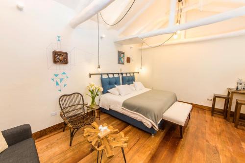 a bedroom with a bed and a table and chairs at X.O Art House in Cusco