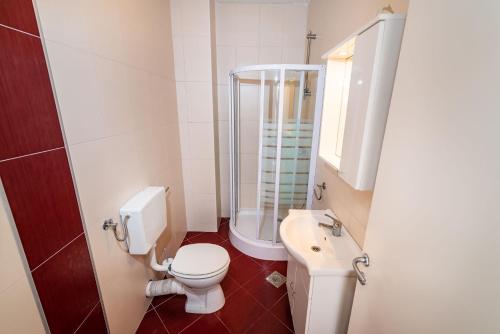 a bathroom with a toilet and a shower and a sink at Apartments Matej in Pag