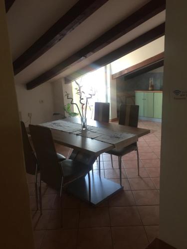 a dining room with a wooden table and chairs at Apartments Tajana in Novigrad Istria