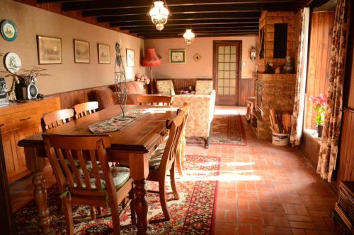 une salle à manger avec une table et des chaises en bois dans l'établissement Les noyers aulnay, à Aulnay