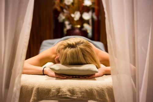 a woman laying on a bed with her head on a pillow at Egnatia Palace Hotel & Spa in Thessaloniki