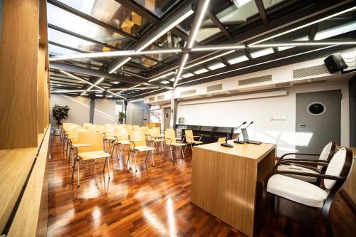 a conference room with tables and chairs and a piano at Egnatia Palace Hotel & Spa in Thessaloniki