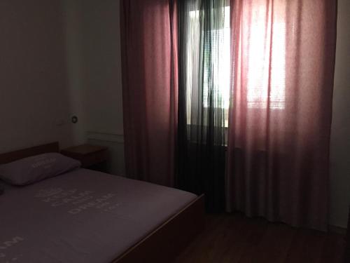a bedroom with a bed and a window with curtains at Apartments Tajana in Novigrad Istria