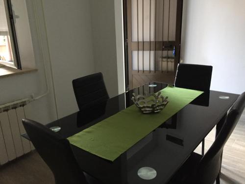 a black dining room table with chairs and a green centerpiece at Apartments Tajana in Novigrad Istria