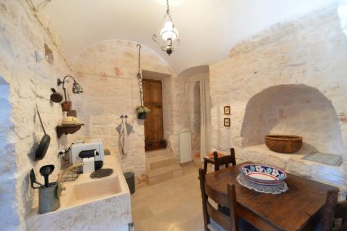 a kitchen with a table and a stone wall at Masseria Oreglia in Ceglie Messapica