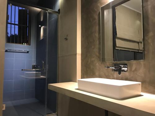 a bathroom with a white sink and a shower at Handagedara Resort & Spa in Mirissa