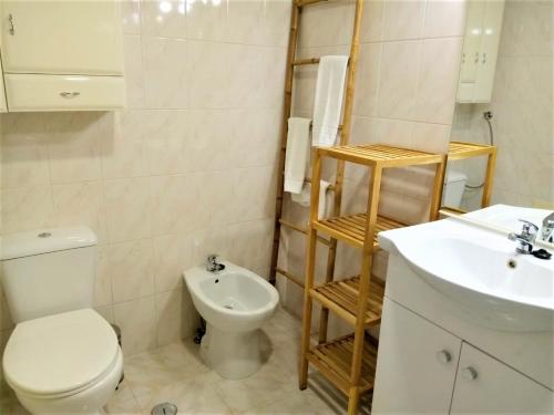 a white bathroom with a toilet and a sink at Sol europa- Vista Mar, 150mt Praia, Wifi in Quarteira