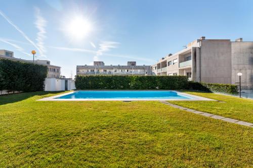 a swimming pool in the middle of a yard at Pink Apartment - Spacious Apartment with Pool in Viana do Castelo