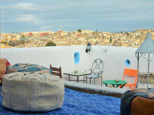 a balcony with tables and chairs and a view of a city at Moroccan Dream Hostel in Fès