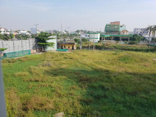 ein Grasfeld mit Gebäuden im Hintergrund in der Unterkunft Big room in Ho-Chi-Minh-Stadt