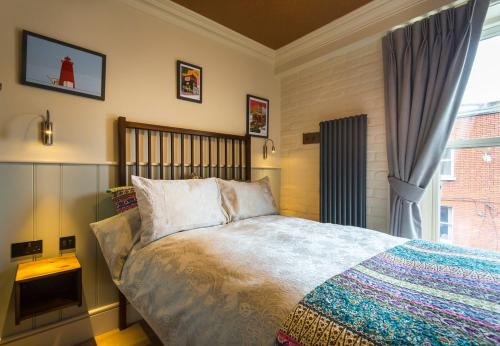 a bedroom with a large bed and a window at McGettigan's Townhouse - Olives & Figs Bistro in Dublin