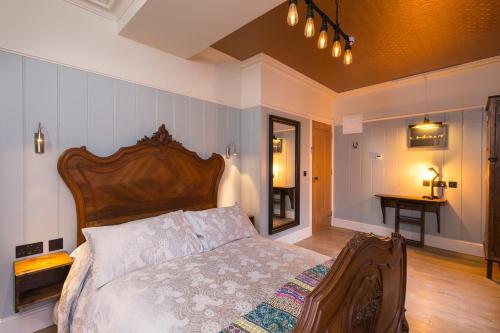 a bedroom with a bed with a wooden head board at McGettigan's Townhouse - Olives & Figs Bistro in Dublin