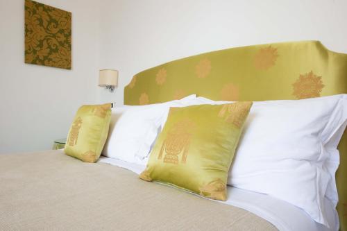 a bed with four pillows on top of it at L'Insolita Reggia in Caserta