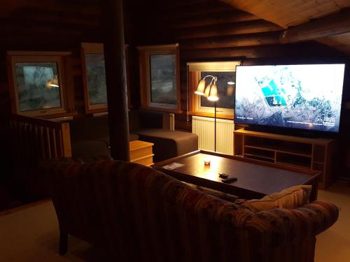 a living room with a couch and a flat screen tv at Akureyri Log Cabin in Akureyri