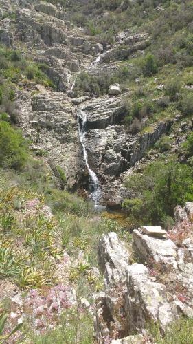 a waterfall on the side of a rocky mountain at B&B LE ISOLE in San Teodoro
