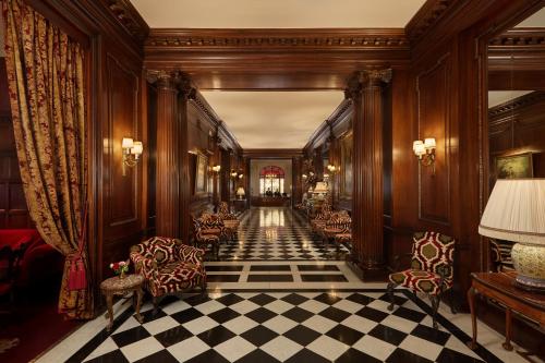 a hallway with chairs and a checkered floor at Hôtel Raphael in Paris