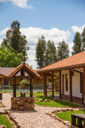 a building with wooden pavilions in a park at Hotel El Molino in Santa Cruz