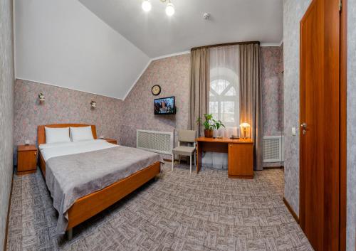 チェレポヴェツにあるHotel Vizitのベッドとデスクが備わるホテルルームです。