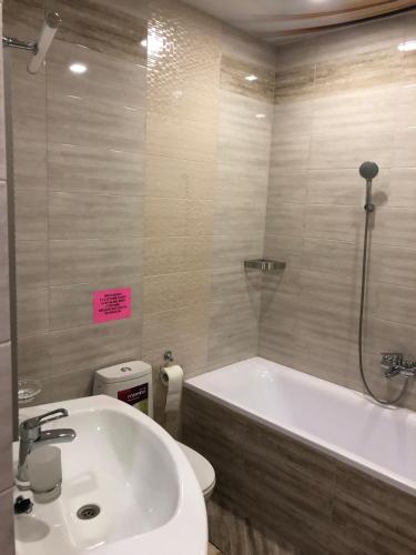 a bathroom with a tub and a toilet and a sink at Motel Kurortnyy & SPA in Shklo