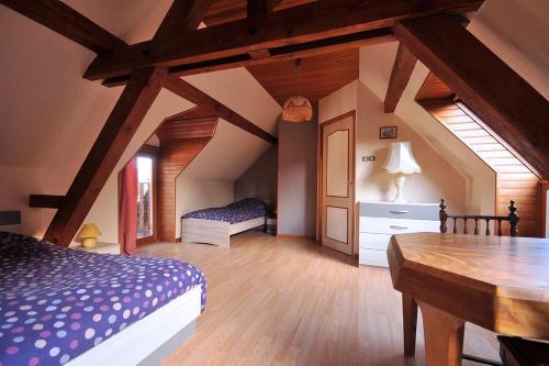1 dormitorio con cama y mesa de madera en GITE DU FLORIMONT CENTRE ALSACE route des vins, en Ingersheim