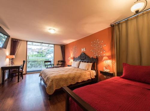 um quarto com uma cama, uma secretária e uma janela em Hotel Boutique Villa Elisa em Arequipa