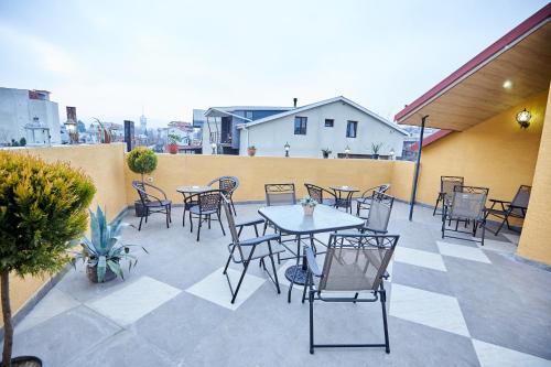 a patio with tables and chairs on a balcony at Hotel Diadema in Tbilisi City