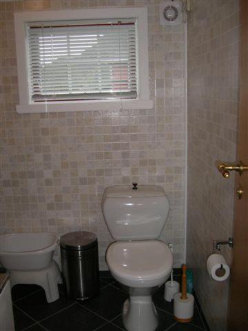 a bathroom with a white toilet and a window at Presthus Gård in Ølve